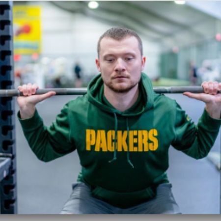Man performing a barbell squat for the Birthday Challenge at our Janesville gym!